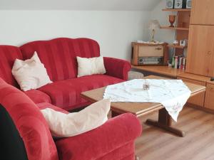 MinsenにあるHoliday Home Ettje by Interhomeのリビングルーム(赤い椅子2脚、コーヒーテーブル付)