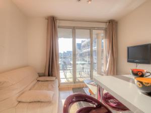 a living room with a couch and a large window at Apartment Blue Bay by Interhome in Deauville