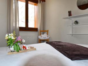 ヴェルビエにあるApartment Mondzeu A258 by Interhomeの花瓶に花が飾られたベッドのある寝室