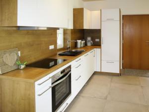 a kitchen with white cabinets and a stove top oven at Holiday Home am Bächle by Interhome in Hofstetten