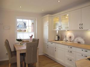 a kitchen with white cabinets and a table and a window at Apartment Hannelore-1 by Interhome in Bübbens