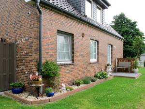 a brick house with plants in the yard at Apartment Hannelore-1 by Interhome in Bübbens