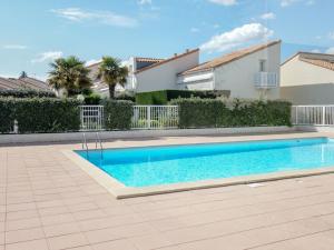 a swimming pool in front of a house at Holiday Home Les Jardins de l'Océan-2 by Interhome in Pontaillac