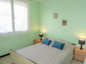 Apartment Vicente by Interhome في سان بيير لا مير: غرفة نوم بسرير ومخدات زرقاء ونوافذ