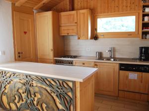 una cucina con mobili in legno e un piano di lavoro di Apartment Bisse-Vieux A-4 by Interhome a Nendaz