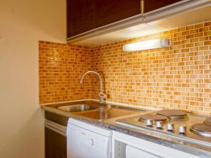 una cucina con lavandino e muro di mattoni di Apartment Les Grandes Platières-4 by Interhome a Tignes