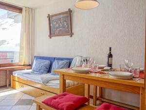 una sala da pranzo con tavolo e divano blu di Apartment Les Grandes Platières-4 by Interhome a Tignes