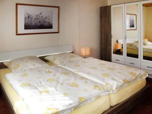 um quarto com uma cama grande e um espelho em Apartment Alte Molkerei-1 by Interhome em Friederikensiel