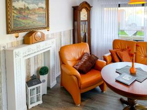 a living room with an orange chair and a table at Apartment Christine by Interhome in Ditzum