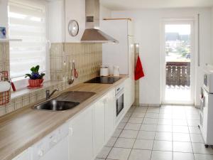 eine Küche mit weißen Schränken, einem Waschbecken und einem Fenster in der Unterkunft Apartment Vogesenblick by Interhome in Heiligenzell