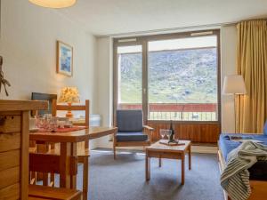 uma sala de estar com uma mesa e um sofá em Apartment Les Tommeuses - Val Claret-19 by Interhome em Tignes