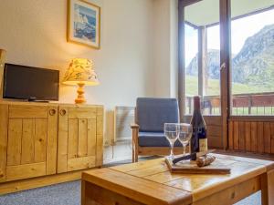 uma sala de estar com uma mesa e uma garrafa de vinho em Apartment Les Tommeuses - Val Claret-19 by Interhome em Tignes