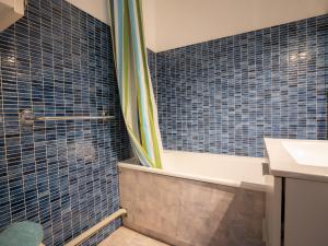 ル・グロー・デュ・ロワにあるApartment Les Jardins du Port-4 by Interhomeの青いタイル張りの壁のバスルーム(シャワー付)