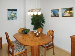 a dining room table with chairs and a wooden table at Apartment Glowe - GLW655 by Interhome in Glowe