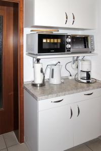 a kitchen with a counter with a microwave and appliances at Apartment Glowe - GLW655 by Interhome in Glowe