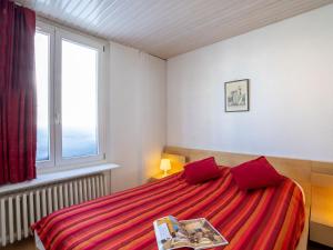 a bedroom with a bed with red sheets and a window at Apartment Neige d'or-2 by Interhome in Tignes