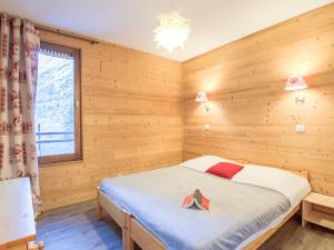 ティーニュにあるApartment Le Curling A-2 by Interhomeの木製の部屋にベッド1台が備わるベッドルーム1室があります。