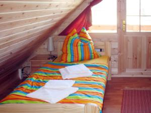 a bed in a wooden room with towels on it at Holiday Home Zum Stolpseefischer by Interhome in Himmelpfort