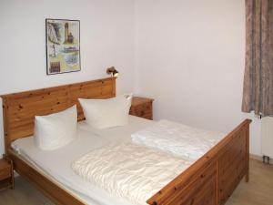 ツェンピンにあるApartment Achterwasser - ZEM100 by Interhomeのベッドルーム1室(白いシーツが備わる木製ベッド1台付)