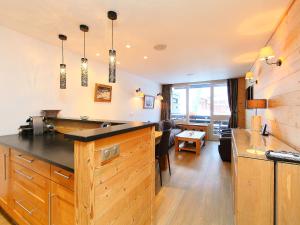 a kitchen with a counter and a living room at Apartment Les Hauts du Val Claret - Val Claret-17 by Interhome in Tignes