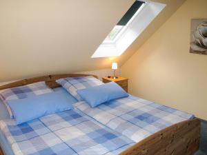 UmmanzにあるHoliday Home Kiebitz by Interhomeのベッドルーム1室(青い枕のベッド1台、窓付)
