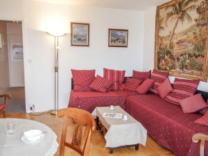 Una sala de estar con un sofá rojo y una mesa. en Studio Le Parc de La Jacotte-3 by Interhome, en Trouville-sur-Mer