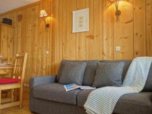 sala de estar con sofá gris y paredes de madera en Apartment Le Curling A - Val Claret-13 by Interhome, en Tignes