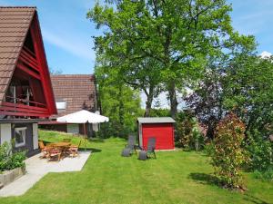 a garden with a red shed next to a house at Holiday Home Svea by Interhome in Wilhelmsdorf