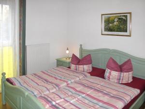 ツィノヴィッツにあるApartment Ostseetrio-3 by Interhomeのベッドルーム(緑色のベッド、紫色の枕付)