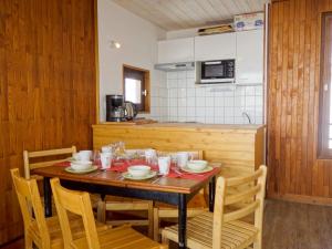 a kitchen with a wooden table with chairs and a tableasteryasteryasteryasteryastery at Apartment Les Moutières B1 et B2 - Val Claret-20 by Interhome in Tignes