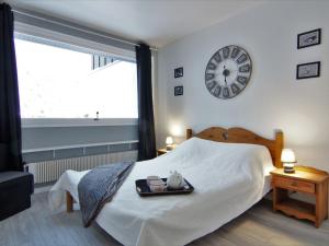 a bedroom with a bed with a clock on the wall at Apartment L'Outa by Interhome in Chamonix-Mont-Blanc