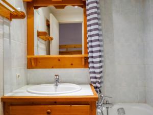 a bathroom with a sink and a mirror and a tub at Apartment Home Club-1 by Interhome in Tignes