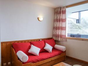 ティーニュにあるApartment Home Club-1 by Interhomeの窓付きの客室で、赤いソファが備わります。