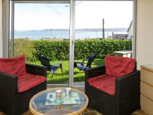un patio con sillas y una mesa y vistas al océano en Holiday Home Roz Amor by Interhome, en Locquémeau