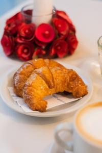 a plate of pastries on a table with a bouquet of roses at Hotel Embajador in San Miguel de Tucumán