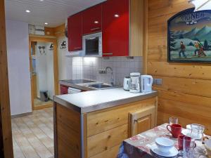 a kitchen with red cabinets and a counter top at Apartment Le Grand Tichot A et B - Val Claret-8 by Interhome in Tignes +13 photos