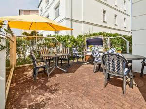 a patio with tables and chairs and an umbrella at Apartment Stolzenfels-2 by Interhome in Ostseebad Sellin