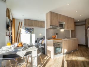eine Küche und ein Wohnzimmer mit einem Tisch und einem Herd in der Unterkunft Apartment Les Tufs - Val Claret-5 by Interhome in Tignes
