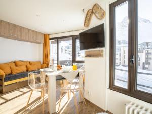 eine Küche und ein Wohnzimmer mit einem Tisch und einem Sofa in der Unterkunft Apartment Les Tufs - Val Claret-5 by Interhome in Tignes