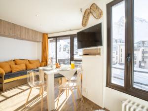 a kitchen and living room with a table and a couch at Apartment Les Tufs - Val Claret-5 by Interhome in Tignes