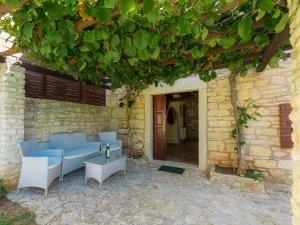 a patio with a blue couch and chairs under a building at Holiday Home Jadranka - ROJ416 by Interhome in Žminj