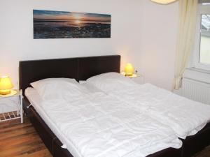 ツェンピンにあるApartment Sonnenblume by Interhomeのベッドルーム(ランプ2つ付)の大きな白いベッド1台