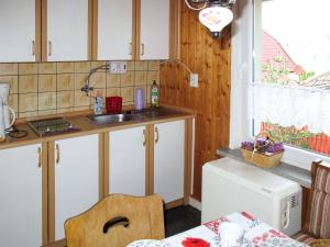 GarzにあるHoliday Home Kaiser by Interhomeの白いキャビネット、シンク、テーブル付きのキッチンが備わります。