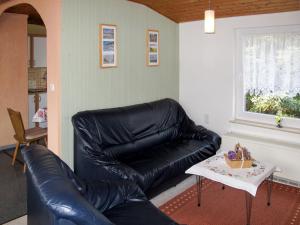 un sofá de cuero negro en una sala de estar con mesa en Holiday Home Kaiser by Interhome, en Garz