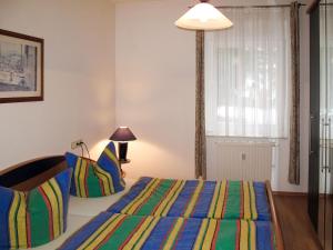 ロディンにあるApartment Haus Berlin-3 by Interhomeのベッドルーム1室(カラフルなストライプ毛布付きのベッド1台付)