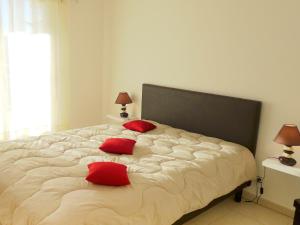 a bedroom with a large bed with red pillows on it at Apartment Terres Marines by Interhome in Nice