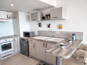 a kitchen with white cabinets and a wooden counter top at Apartment Terres Marines by Interhome in Nice