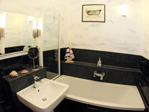 ein Badezimmer mit einer weißen Badewanne und einem Waschbecken in der Unterkunft Apartment Schlüterstrasse by Interhome in Berlin