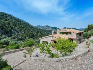 a house on a hill with mountains in the background at Holiday Home Es Barracar - CMI105 by Interhome in Caimari