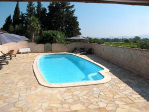 - une piscine sur une terrasse avec des chaises et un parasol dans l'établissement Holiday Home Mas du Combaud - RSA170 by Interhome, à Roquebrune-sur Argens